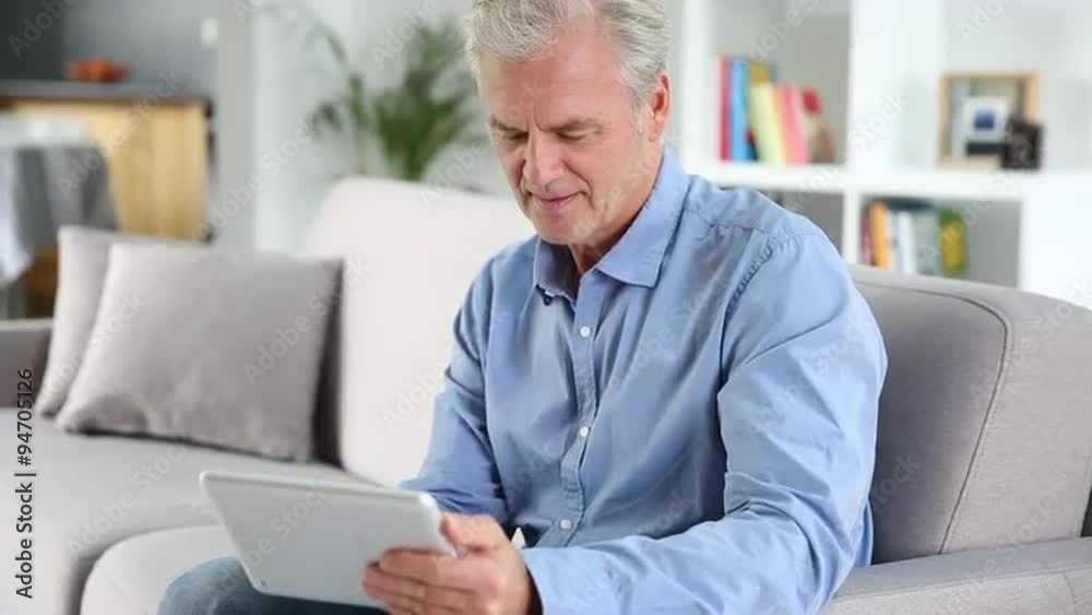 Mature man using a tablet pc at home Mature man using a tablet pc at home