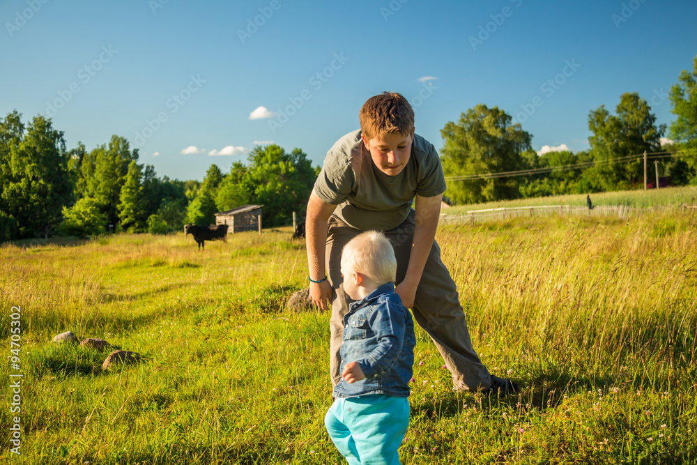Two boys  playing on a meadow.
