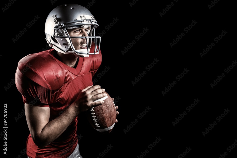 Composite image of american football player holding ball