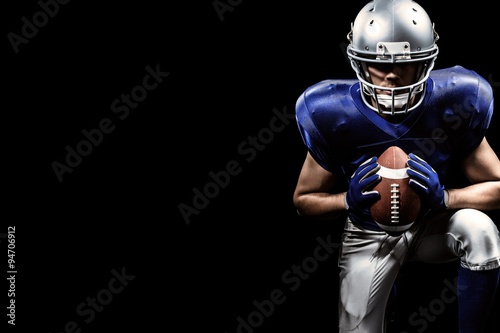 Composite image of american football player holding ball