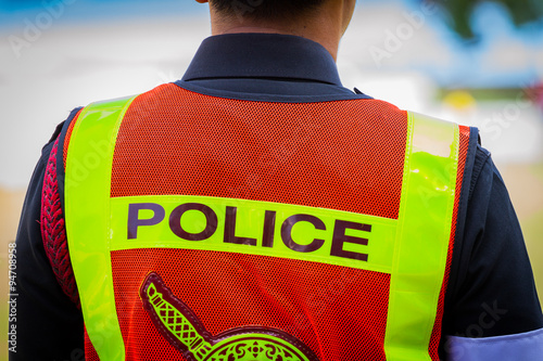 back of a Thai police officer's jacket with the word police writ