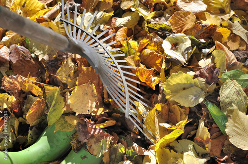 râteau à feuilles et bottes dans feuillage au sol
