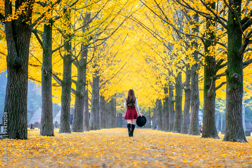 Fototapeta premium Beautiful Girl with Yellow Leaves in Nami Island, Korea