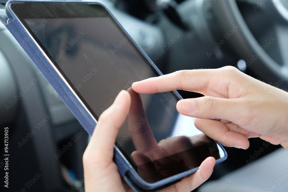 Woman Sitting in the Car and Using digital tablet.Business technology concept.