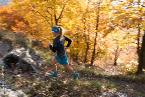 cross country trail female runner with long hair in autumn colorful forest