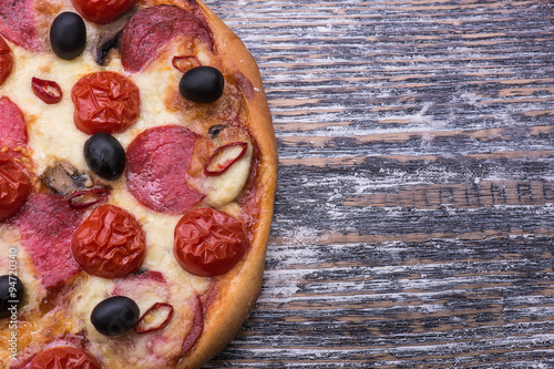 Italian pizza with mozzarella on wooden background