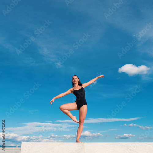 Young beautiful ballerina dancing outdoors in a modern environme