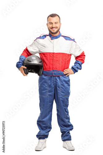 Young male car racer in overalls holding a helmet