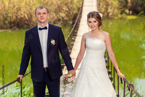 Couple hand in hand on suspension bridge © Mironifamily