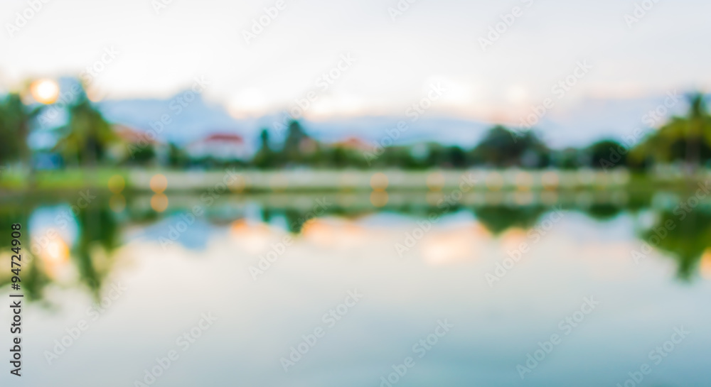 blur image of lake and sunset sky in background