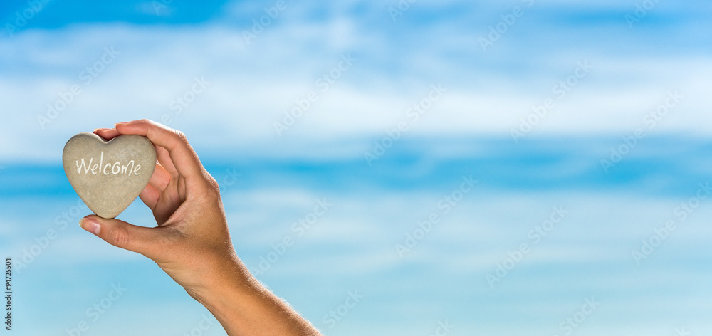 Heart held by hand against blue sky Heart held by hand against blue sky