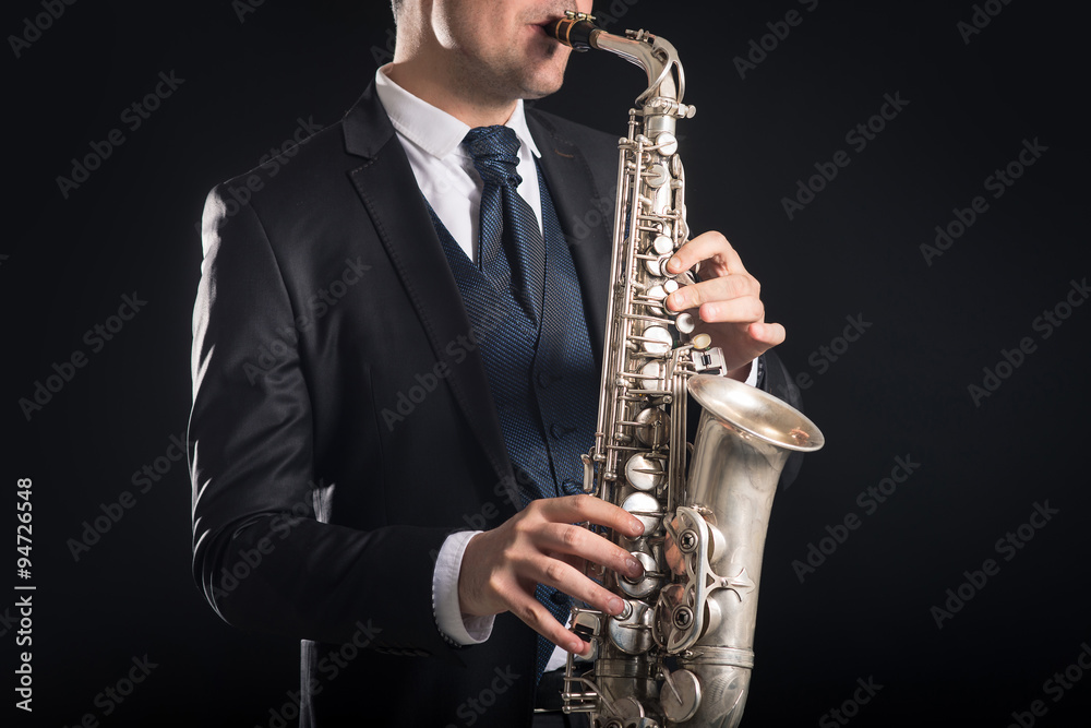 Fototapeta premium Saxophone player man isolated against black background. Close up