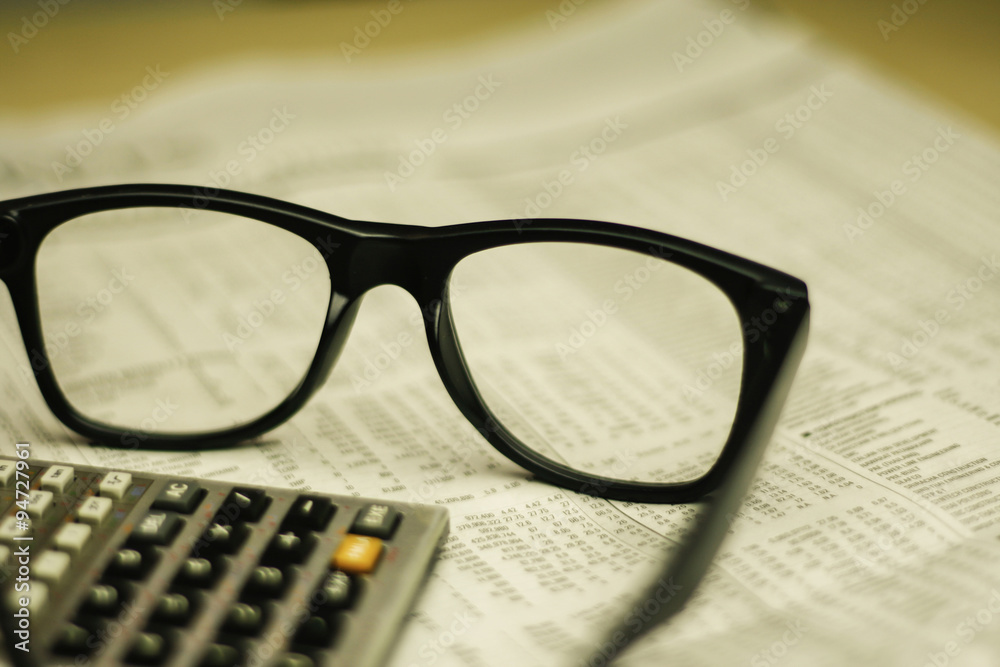 glasses and calculator on newspaper glasses and calculator on newspaper