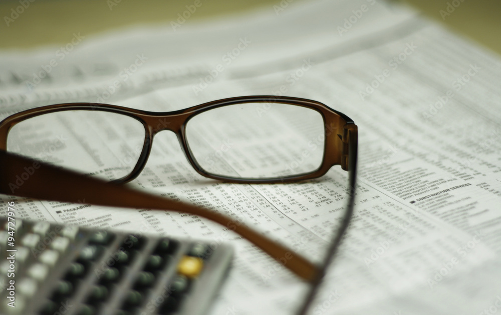 glasses and calculator on newspaper glasses and calculator on newspaper