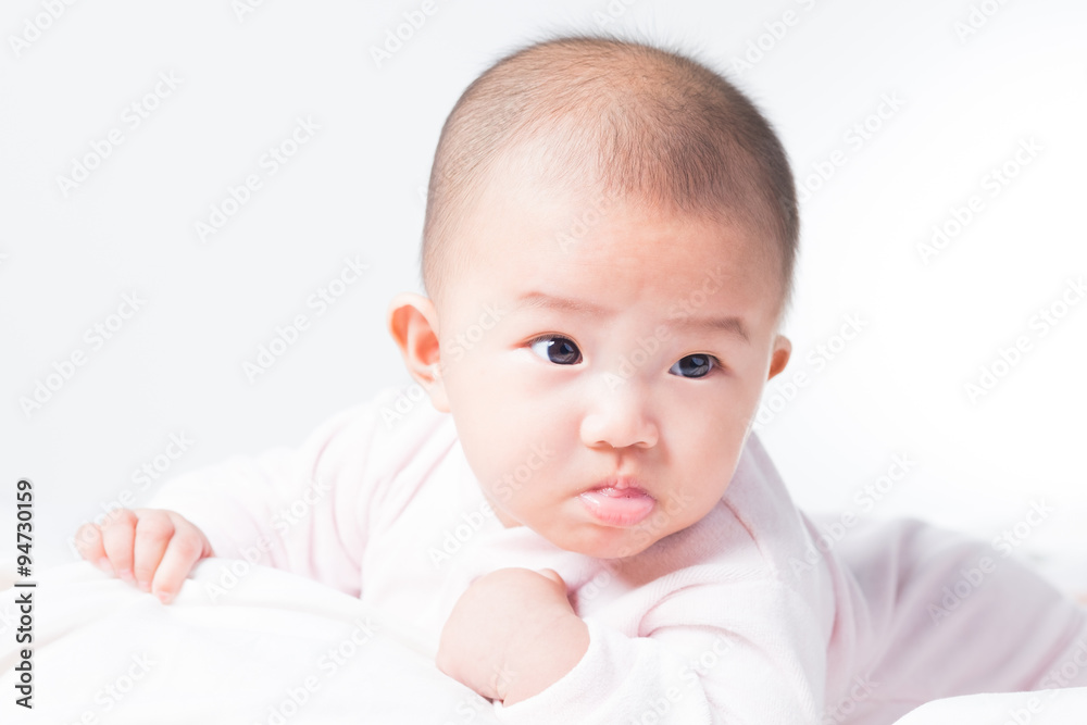 Adorable Asian baby 4-5 months old on white bed & background. Portrait studio light isolated.