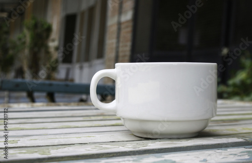 Coffee cup on wood table with blur background