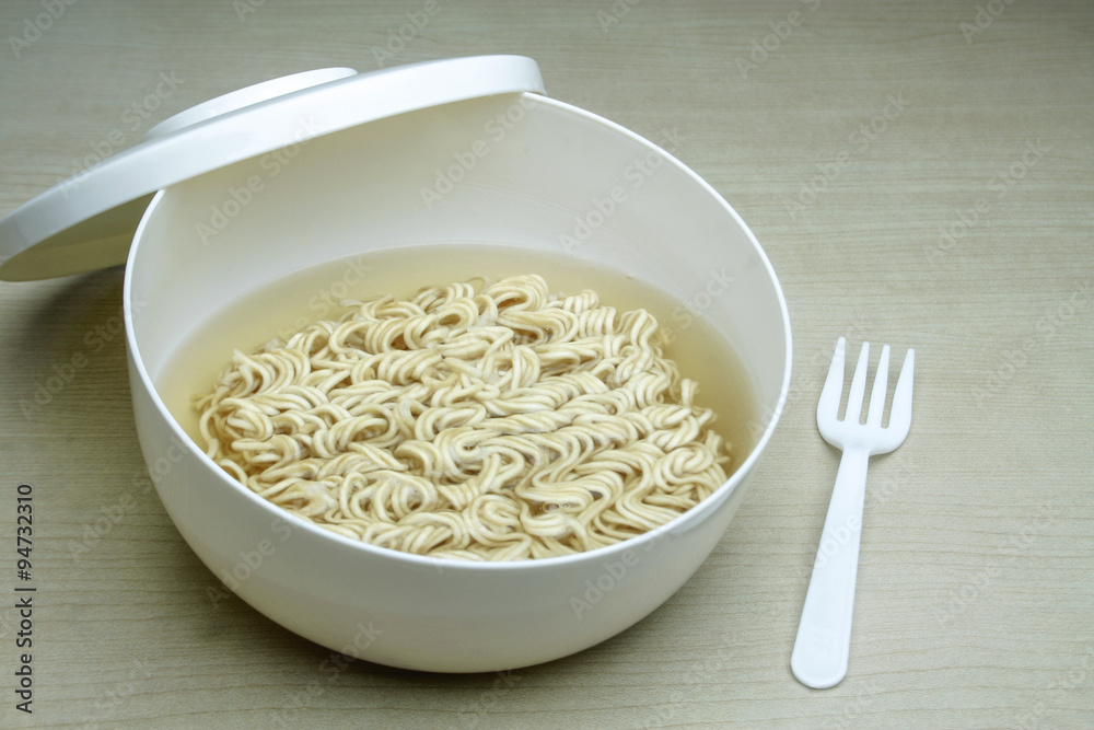 Instant noodles in white dish on wood background Instant noodles in white dish on wood background
