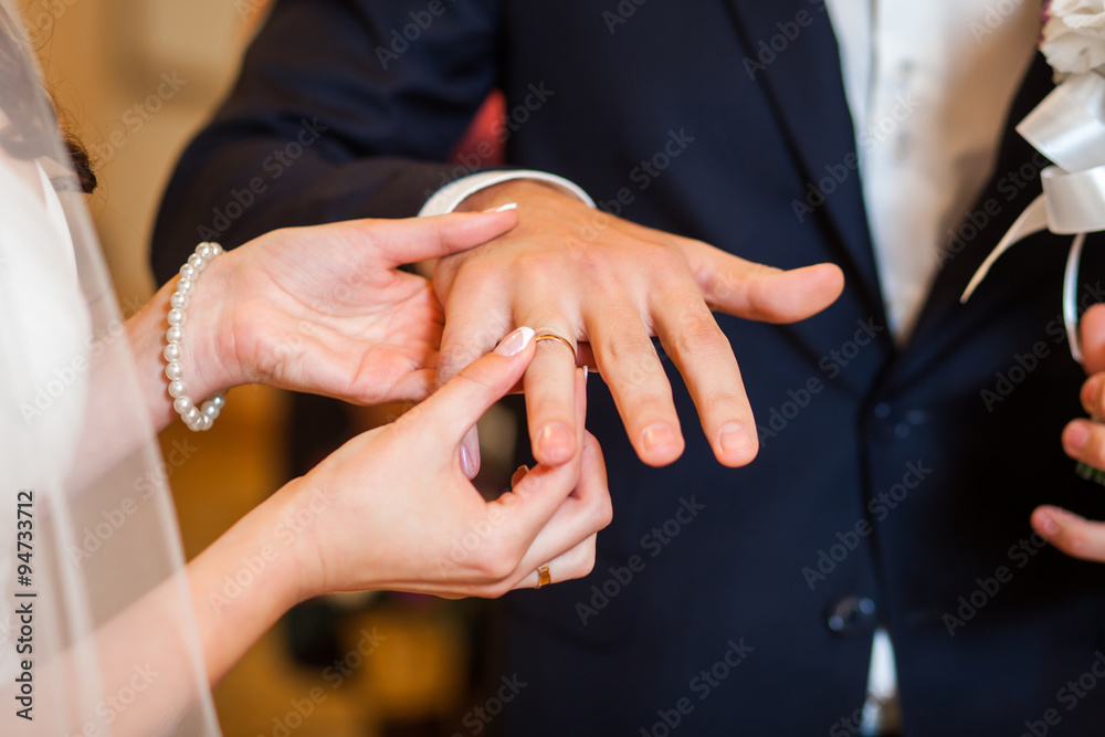 Fototapeta premium Happy bride and groom at wedding wearing rings