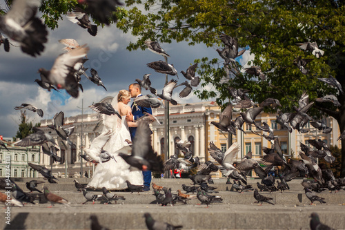 Husband and wife near building with doves flying