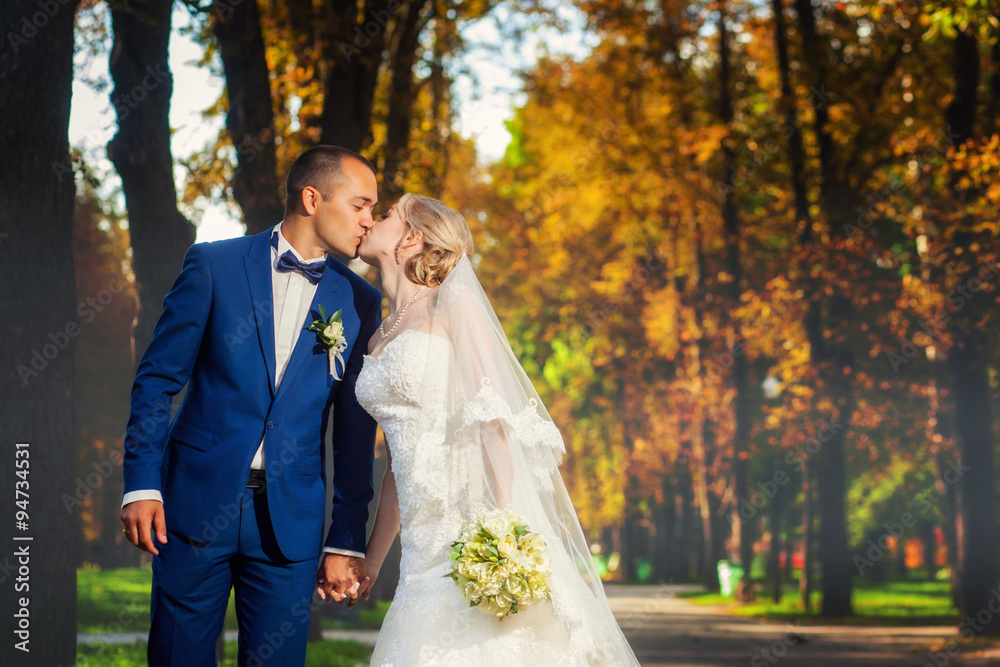 Wedding couple kissing in park Wedding couple kissing in park