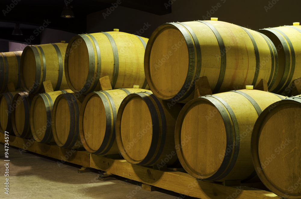 Wine barrels with red wine leak in a cellar Wine barrels with red wine leak in a cellar