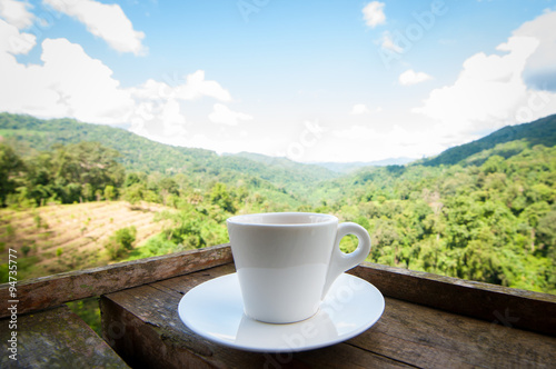 coffee cup on wooden with blurry nature background