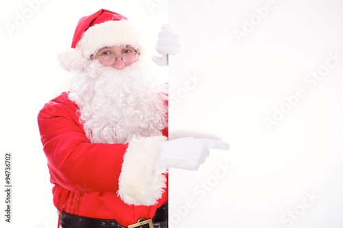 Kind Santa Claus pointing in white blank sign, isolated on white background © rogerphoto