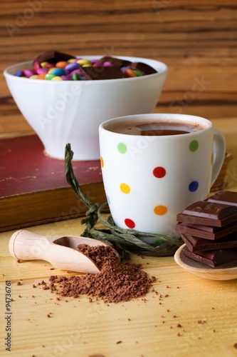 Hot chocolate drink next to bowl with sweets