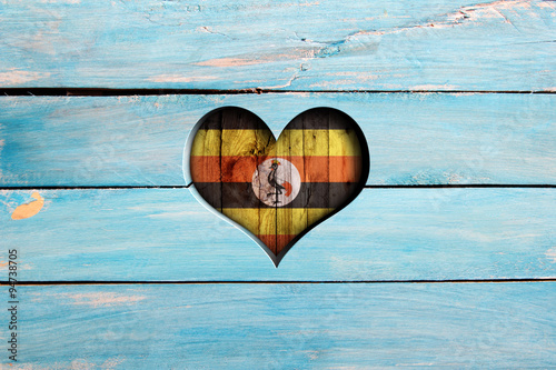 Love Uganda. Heart and flag on a blue wooden board