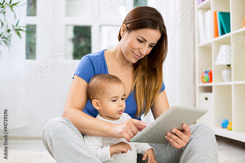 Young mother larning child how to use tablet photo