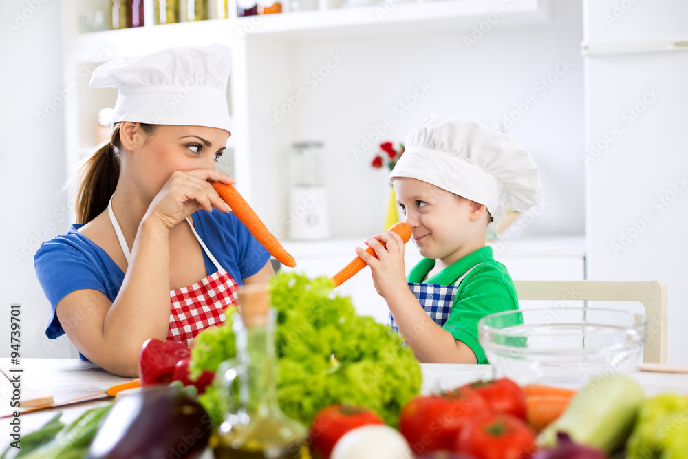 Mother and son putting carrots on nose and playing together in k Mother and son putting carrots on nose and playing together in k