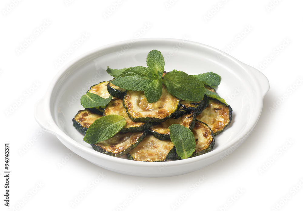 Sauteed zucchini with mint leaf on a white background Sauteed zucchini with mint leaf on a white background