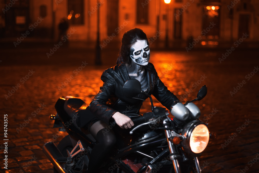 Young woman with Halloween makeup sitting on the motorbike . Street portrait. 