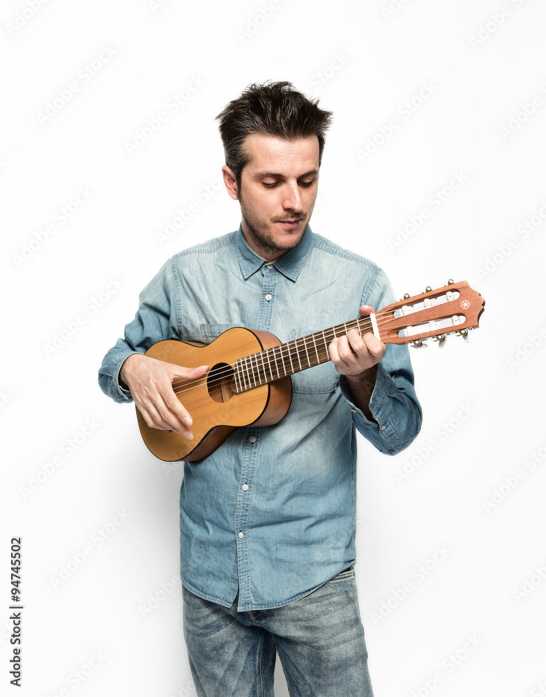 Musico tocando una guitarra pequeña sobre fondo blanco