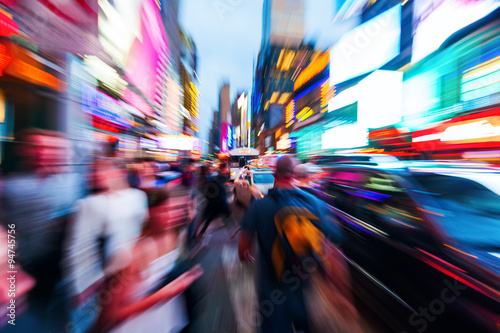 Menschenmengen und städtischer Verkehr im nächtlichen Manhattan mit kreativem Zoomeffekt