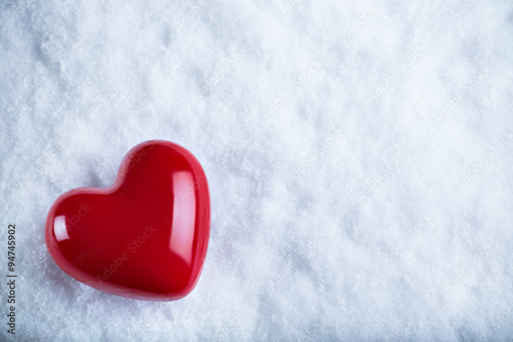 Red glossy heart on a frosty white snow background. Love and St. Valentine concept