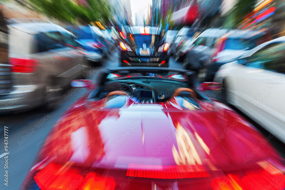 Fototapeta premium Bild mit kreativem Zoom-Effekt von einem Cabrio im Stadtverkehr
