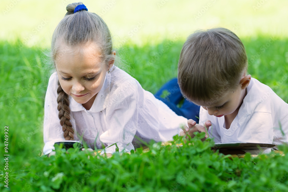 Children using PC and smartphone laying Children using PC and smartphone laying