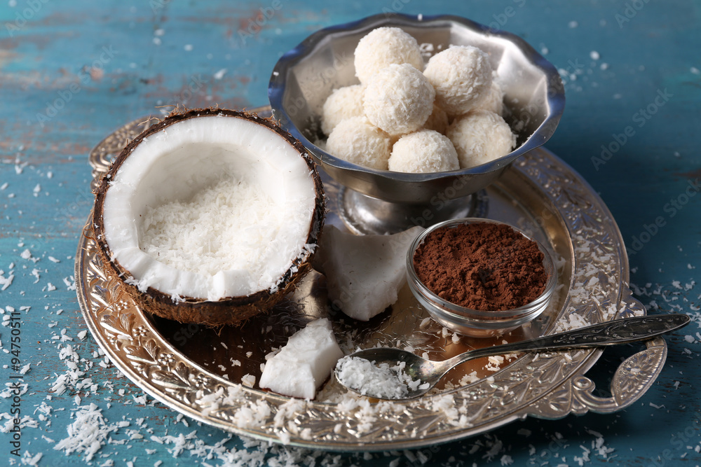 Homemade candies in coconut flakes and ingredients on color wooden background Homemade candies in coconut flakes and ingredients on color wooden background