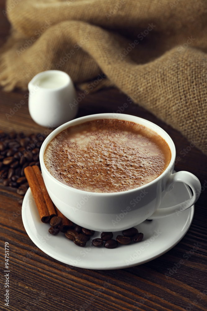 Cup of coffee with cream and coffee beans on wooden background Cup of coffee with cream and coffee beans on wooden background