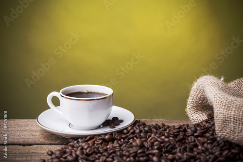 Cup with coffee against grunge background