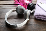 Headphones and sport equipment on old wooden background