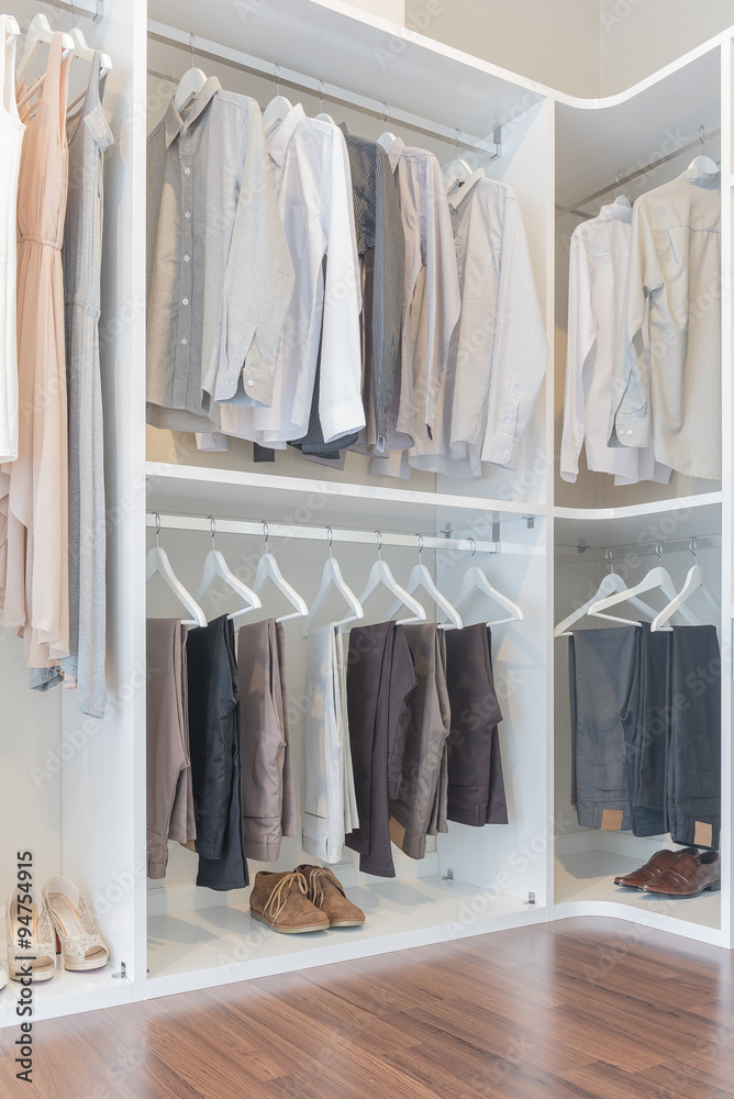 dress and shirts hanging on rail in white wardrobe