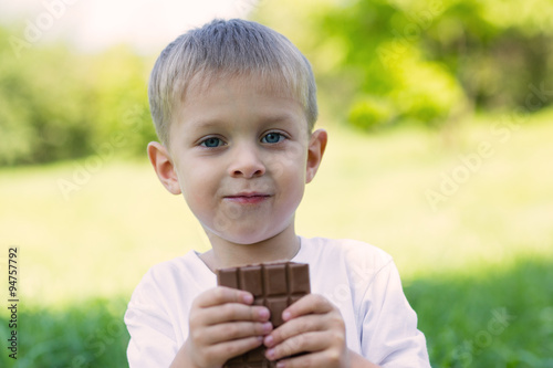 Boy eating chocolate with pleasure