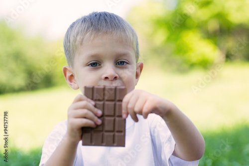 Boy is eating a chocolate bar