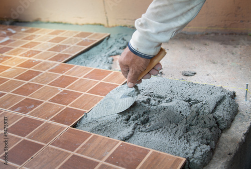 floor tiling by manual worker
