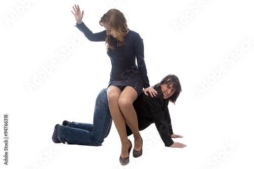 Fotografie Woman sitting on man in jacket and beating him