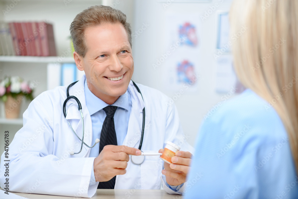 Smiling cardiologist talking to the patient Smiling cardiologist talking to the patient