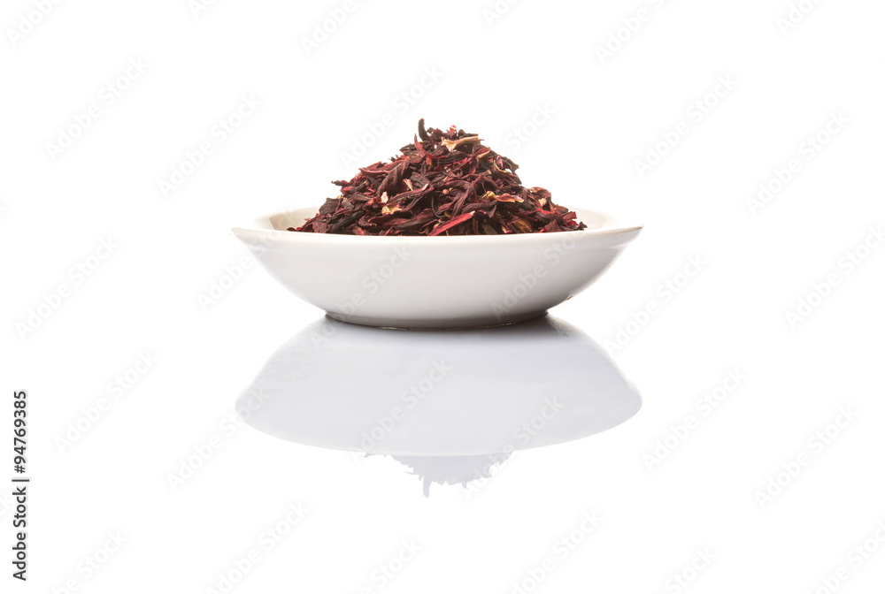 Dried red hibiscus tea leaves in white bowl over white background Dried red hibiscus tea leaves in white bowl over white background
