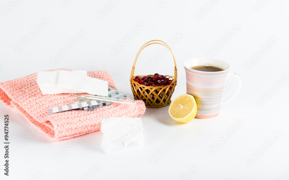 warm scarf, a thermometer, lemon and cranberry juice on a white warm scarf, a thermometer, lemon and cranberry juice on a white